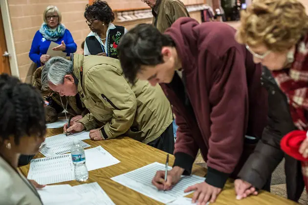 Iowa caucus voters fill out their ballots.