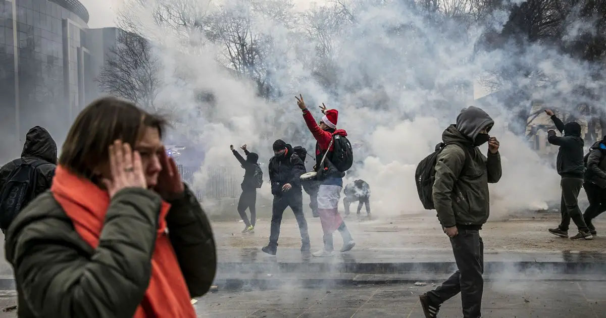 Demonstrators amid a smog of tear gas fired by riot police