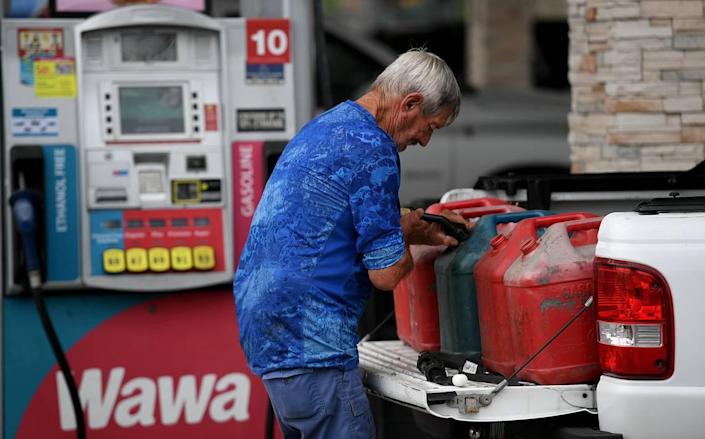 A man fills several gas tanks in the back of his truck at the Wawa station on First Street in Bradenton on May 12, 2021. Several gas stations in town have run out of gas, but local officials say there&#x002019;s plenty of fuel arriving at Port Manatee.