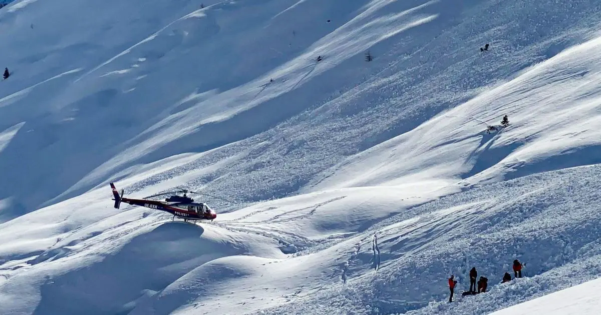 A police helicopter and emergency teams work at the site of an avalanche