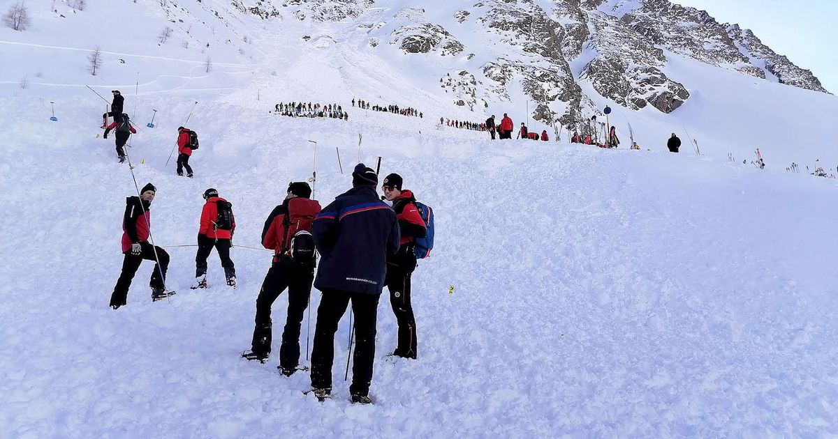 Rescue workers stand at the Rettenbach glacier near Soelden after five people were rescued after being hit by an avalanche