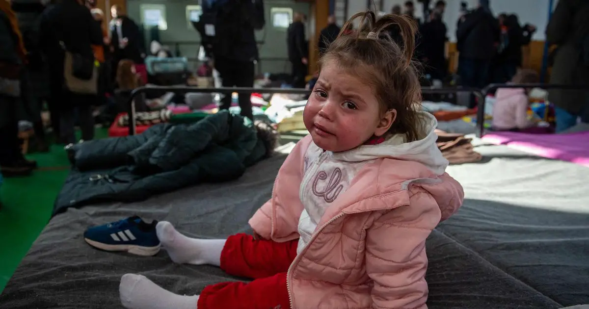 A girl cries as she sits on a camp bed at a temporary shelter for Ukrainian refugees at the border crossing in Ubla, eastern Slovakia, on February 27, 2022. - The UN refugee agency said on February 27, 2022 more than 368,000 people had fled Ukraine since Russia invaded on Thursday, February 24, 2022. (Photo by PETER LAZAR / AFP) (Photo by PETER LAZAR/AFP via Getty Images)