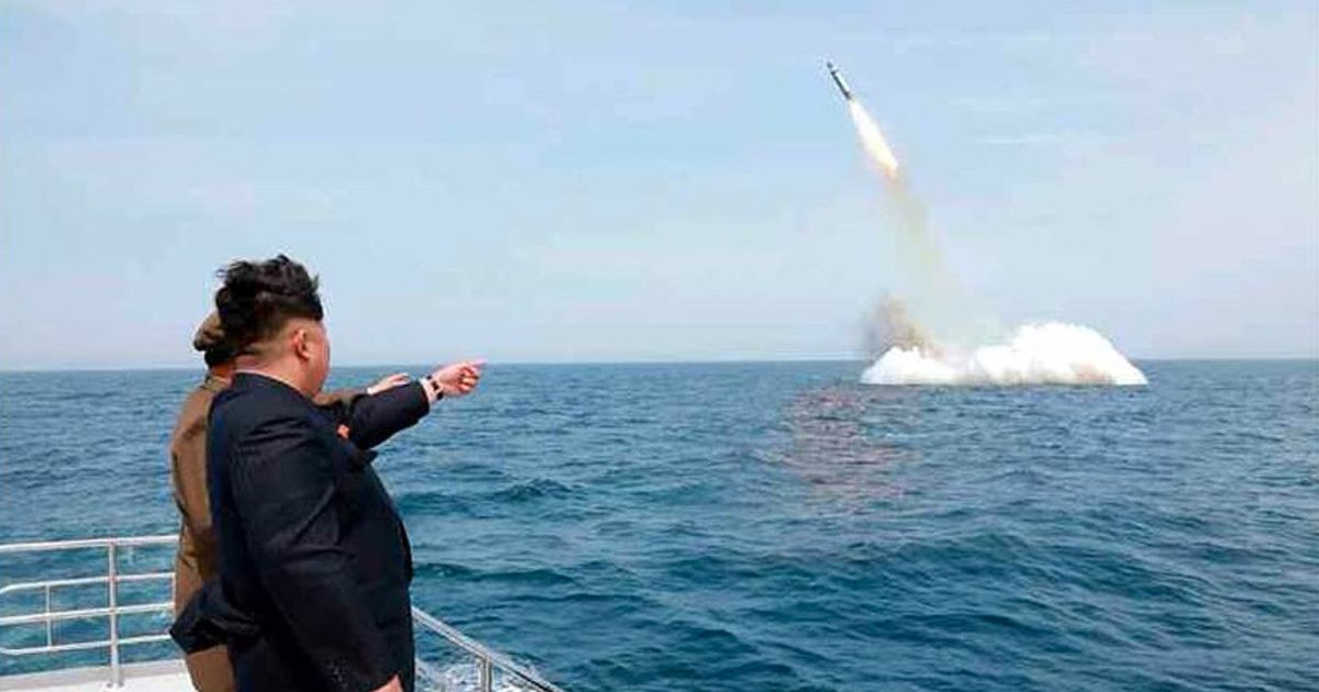 North Korean leader Kim Jong-Un smiling while observing an underwater test-fire of a submarine-launched ballistic missile