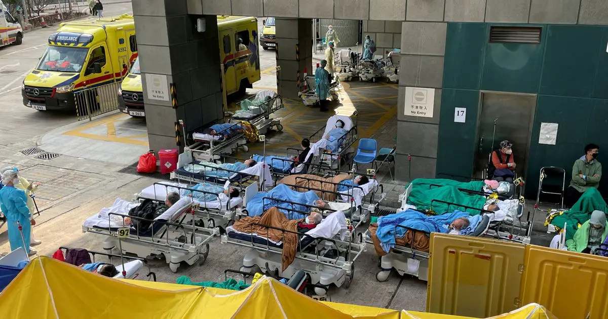 Overrun hospitals in Hong Kong forced to leave Covid patients on beds in car parks