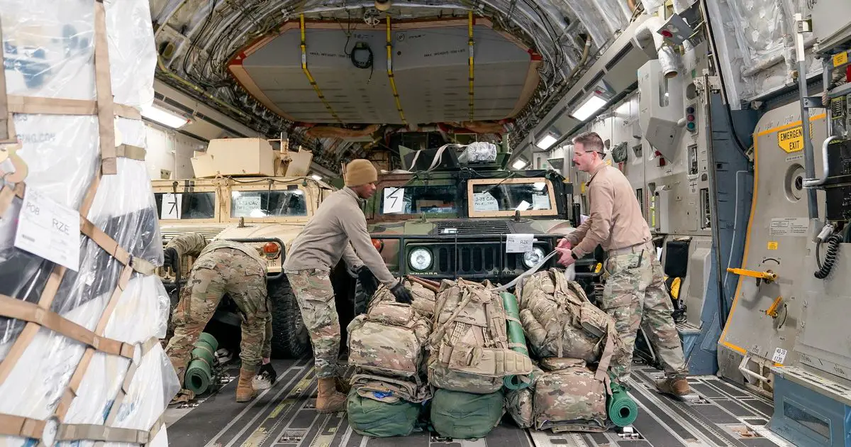 Soldiers from the 82nd Airborne Division secure equipment aboard a C-17 transport plane for deployment to Eastern Europe amid escalating tensions between Ukraine and Russia